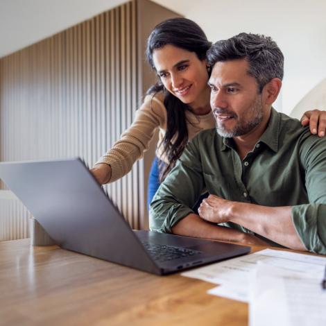 Casal sorridente observa o computador